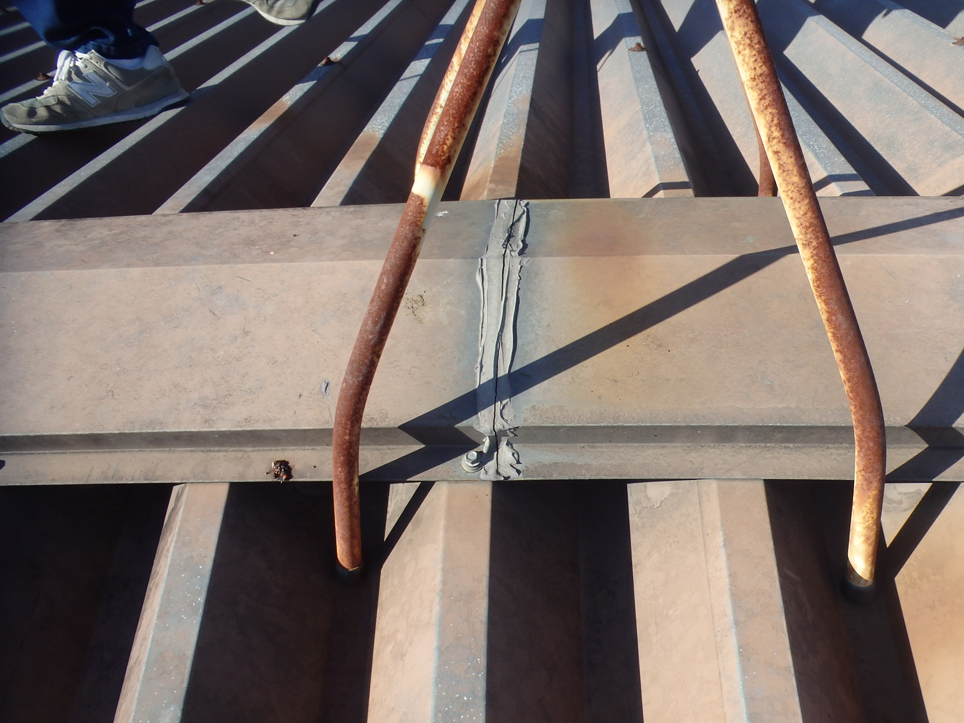 朝日町の社員寮の折板屋根の棟板金のシール劣化で亀裂が発生している状況