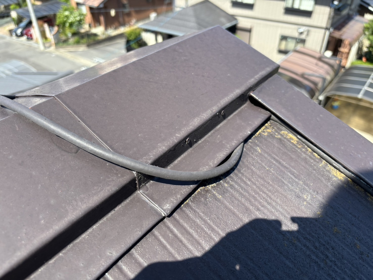 東員町のスレート素材のコロニアル屋根無料屋根診断、棟板金の間にアンテナ配線で浮いている状況