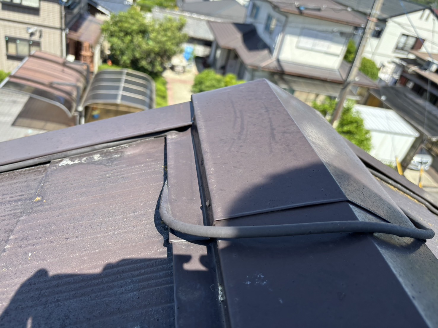 東員町のスレート素材のコロニアル屋根無料屋根診断、棟板金の間にアンテナ配線で浮いている状況左側