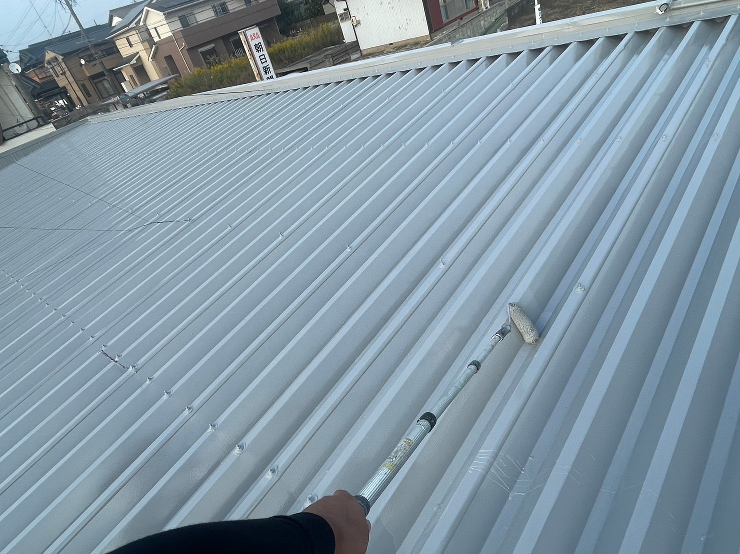 鈴鹿市の店舗折板屋根塗装中塗り作業中２