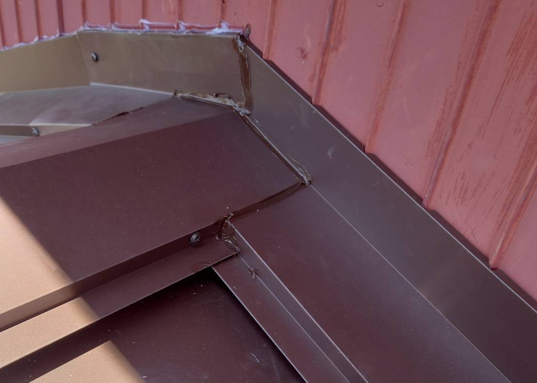 川越町のカラーベスト屋根カバー工法にて施工中、水切り板金の設置状況