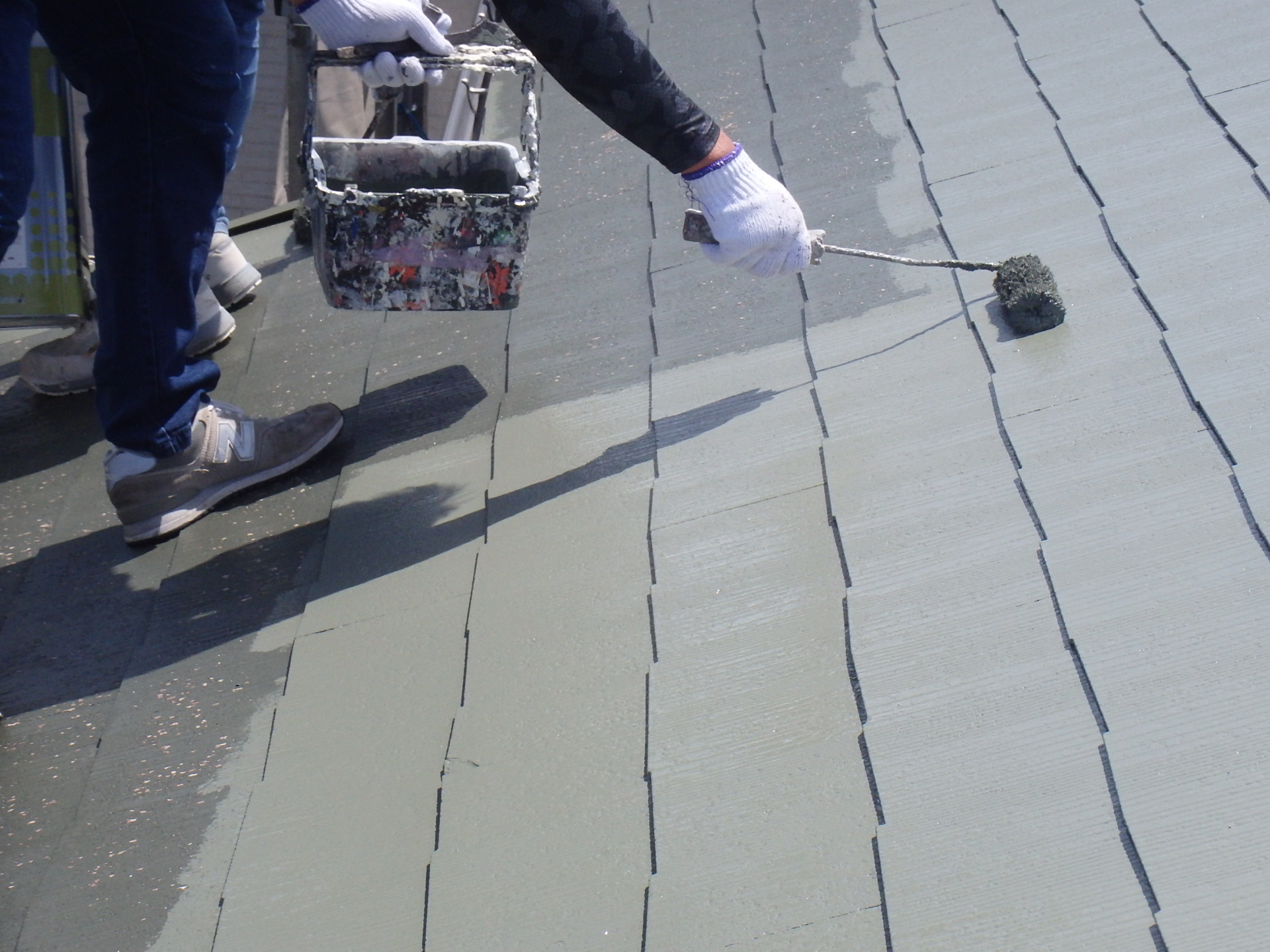 四日市市三滝台にてカラーベスト屋根塗装、中塗り塗装している風景