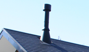 切妻屋根の上に、棟木を外して煙突が出ている。